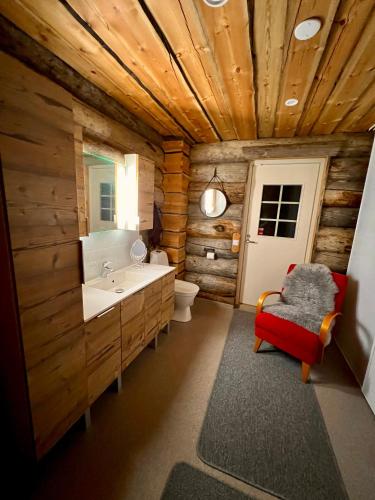 a log bathroom with a sink and a toilet at Villa Kelo in Rovaniemi