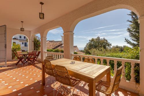 an outdoor patio with a wooden table and chairs at TOP VILLA Casa Anna Private Pool Garden Seaview in Benalmádena
