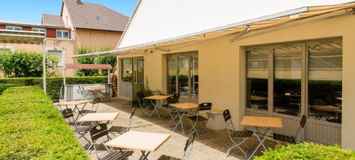a patio with tables and chairs outside of a building at Campanile Mulhouse - Morschwiller in Morschwiller-le-Bas