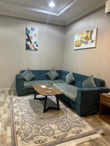 a living room with a blue couch and a table at سكون سويت للشقق الفندقية in Hail