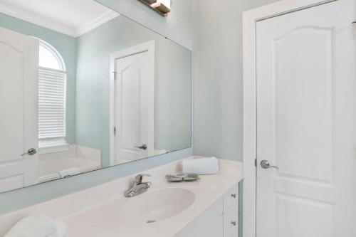 een witte badkamer met een wastafel en een spiegel bij Perdido Sunrise 9b By Pkrm in Pensacola