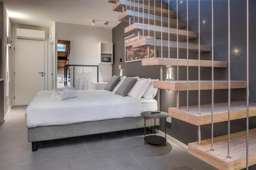 a bedroom with a white bed and a staircase at Forum Suites in Verona