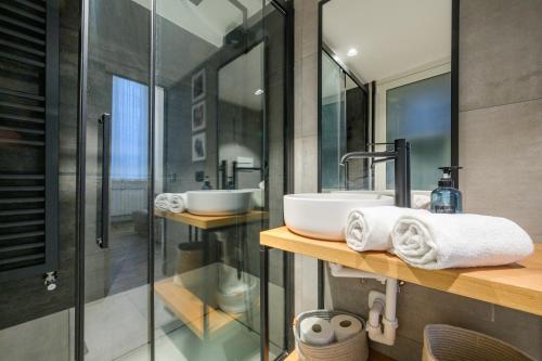 La salle de bains est pourvue de 2 lavabos et d'une douche en verre. dans l'établissement Le Erbe - GenovaInRelax, à Gênes