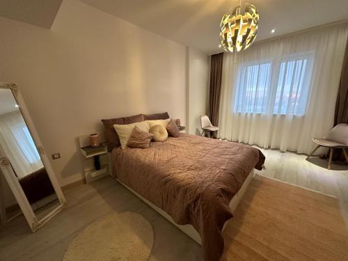 una camera con un grande letto e un lampadario a braccio di Cherry Apartment a Bucarest