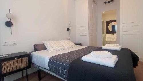a bedroom with a bed with two towels on it at Calle Real con patio in Ferrol
