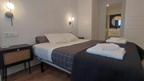 a bedroom with a bed with two towels on it at Calle Real con patio in Ferrol
