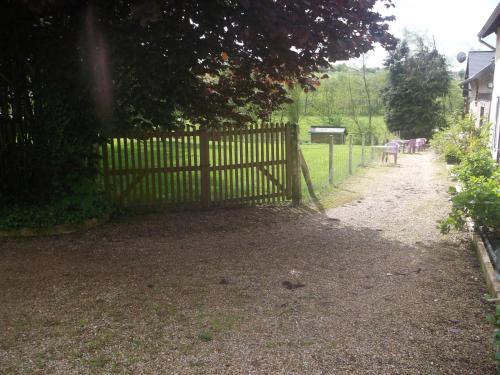 a wooden fence in a yard with animals in a field at Logis Hôtel Restaurant Auberge Saint Martin in Surville