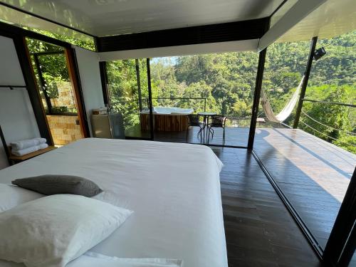 Schlafzimmer mit einem Bett und Blick auf eine Terrasse in der Unterkunft La ceiba cabaña in La Vega