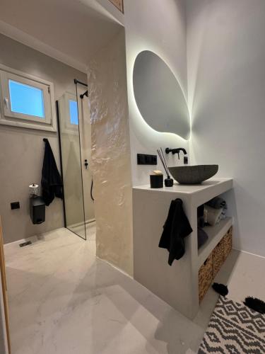 La salle de bains est pourvue d'un lavabo et d'un miroir. dans l'établissement Flash house petite, à Spetses