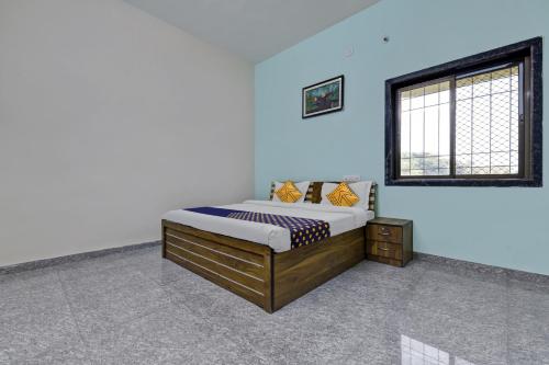uma cama num quarto com uma parede azul em SPOT ON Shree Murti Nandan em Kumbhalgarh