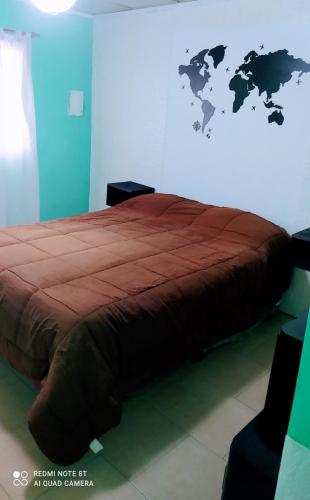 1 dormitorio con 1 cama con un mapa mundial en la pared en El Descanso! en Carhué