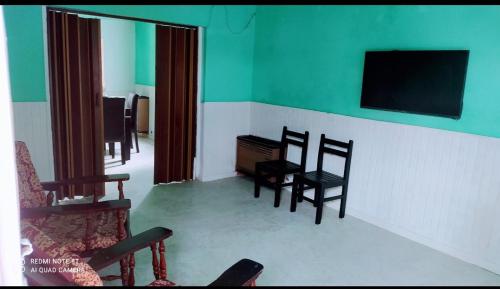 sala de estar con sillas y TV de pantalla plana en El Descanso! en Carhué