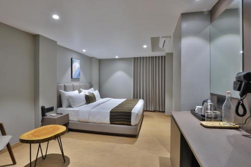 a hotel room with a bed and a desk at Hotel Shivashish in Ahmedabad