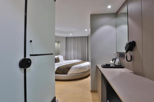 a hotel room with a bed and a kitchen at Hotel Shivashish in Ahmedabad