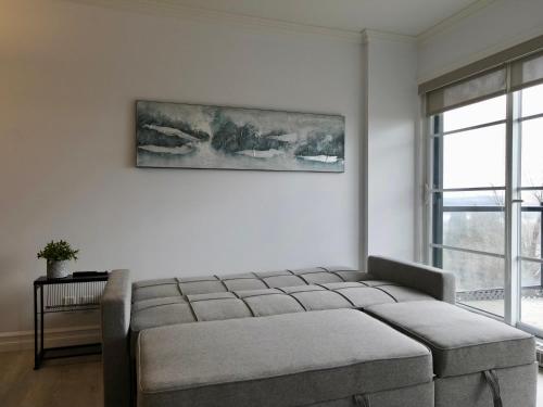 a white room with a bed and a painting on the wall at Modern Loft Chute-Montmorency in Boischâtel