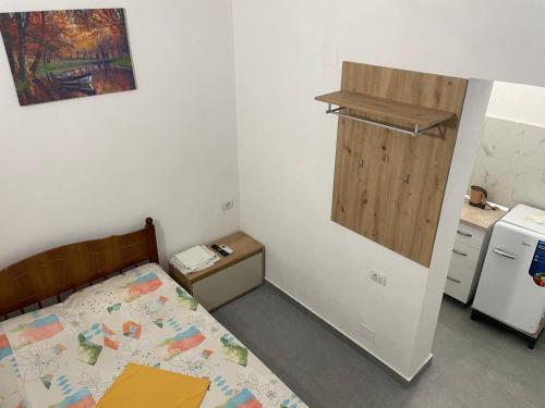 a small bedroom with a bed and a kitchen at Happy Corner Guest House in Shkodër