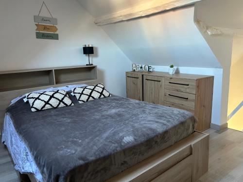 um quarto com uma cama e uma cómoda em madeira em Appartement le petit Royal em Cormelles