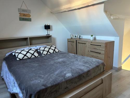 a bedroom with a bed and a wooden dresser at Appartement le petit Royal in Cormelles