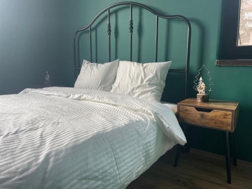 - une chambre bleue avec un lit blanc et une tête de lit en métal dans l'établissement Casa Iacob, à Buşteni