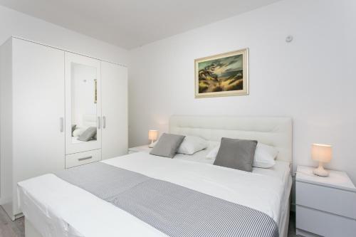 um quarto branco com 2 camas e 2 candeeiros em Apartment Dupčić em Dubrovnik