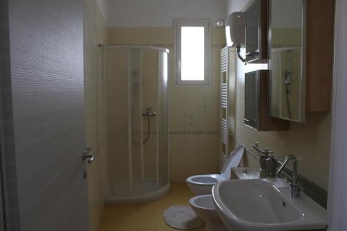 La salle de bains est pourvue de 2 toilettes, d'un lavabo et d'une douche. dans l'établissement AFFITTACAMERE MONTE OLIMPO, à Galatone