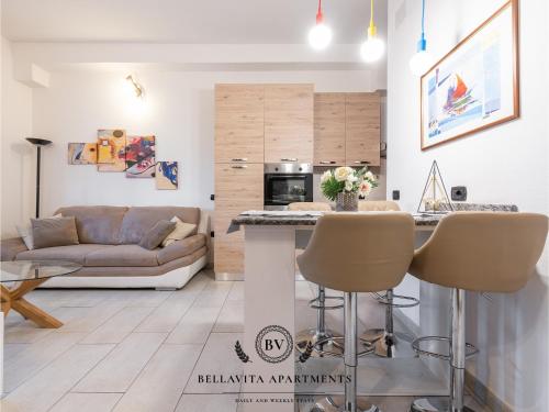 a kitchen and living room with a couch and a table at BellaVita Apartments in Assemini