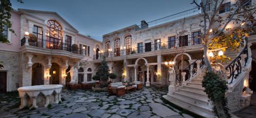 a large building with a stone courtyard with a staircase at Sacred House in Urgup