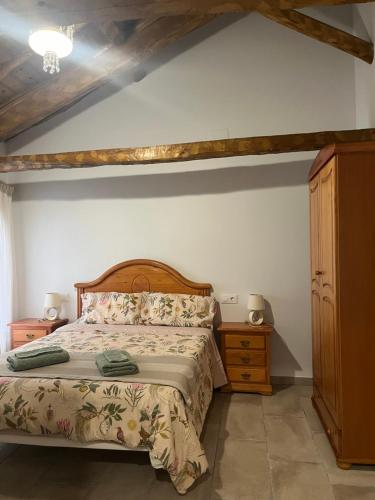 a bedroom with a bed with a wooden headboard and a dresser at Casa Damajuana 