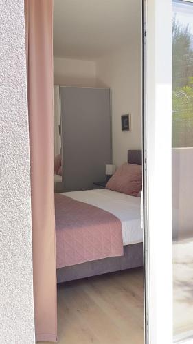 a bedroom with a bed and a large mirror at Arte Oliva in Grebaštica