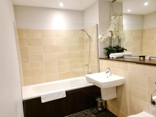 a bathroom with a sink and a bath tub and a toilet at VCity ApartHotels Glasgow Central in Glasgow