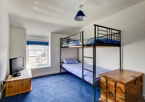 1 Schlafzimmer mit 2 Etagenbetten und einem TV in der Unterkunft Bell Haven in Swanage
