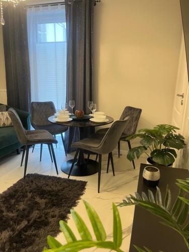 - une salle à manger avec une table et des chaises dans l'établissement Apartamenty Kielce- APARTAMENT SZMARAGD przy zalew kielecki, faktura, à Kielce