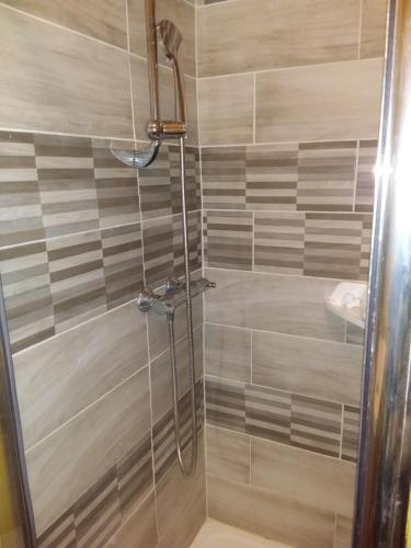 une douche avec une porte vitrée dans une salle de bain dans l'établissement Le Dalton, à Boulogne-sur-Mer