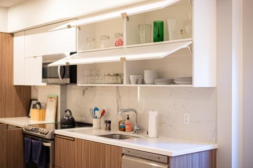 una cocina con armarios blancos y fregadero en Luxury Apartment In The Prime Hollywood Location en Los Ángeles