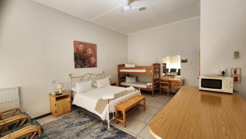 a living room with a bed and a table at Country Village in Graaff-Reinet