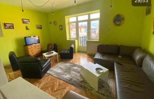 a living room with a couch and a tv at NEWBORN CENTER hostel in Pristina