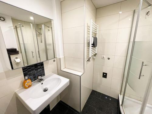 biała łazienka z umywalką i prysznicem w obiekcie Business Apartment Altstadt w Bremie