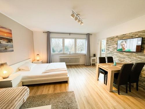 1 dormitorio con cama, mesa y TV en Business Apartment Altstadt en Bremen