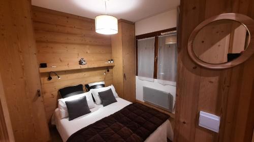 um quarto com uma cama e um espelho em Le COCON DES NEIGES MONTGENEVRE em Montgenèvre