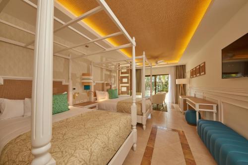a hotel room with two beds and a couch at Bahia Principe Luxury Esmeralda All Inclusive - Newly Renovated in Punta Cana