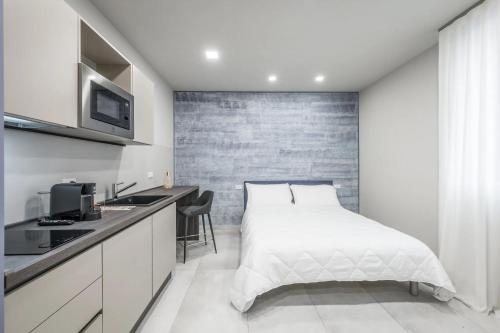 a white bedroom with a bed and a sink at Borgo degli Ulivi in Formigine