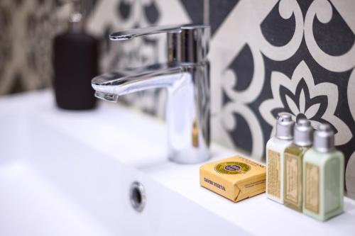 - un lavabo avec 2 bouteilles de savon et un robinet dans l'établissement Magnifique appartement au centre-ville de Nice, à Nice