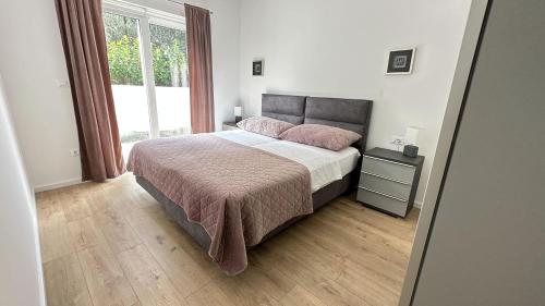 a bedroom with a large bed and a window at Arte Oliva in Grebaštica
