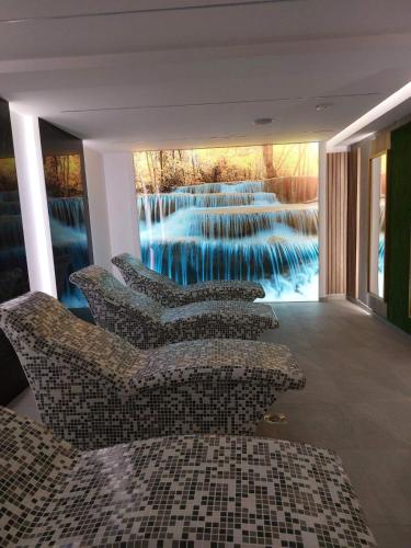 a lobby with couches and a mural of a waterfall at President Kop Apartman 106 in Kopaonik