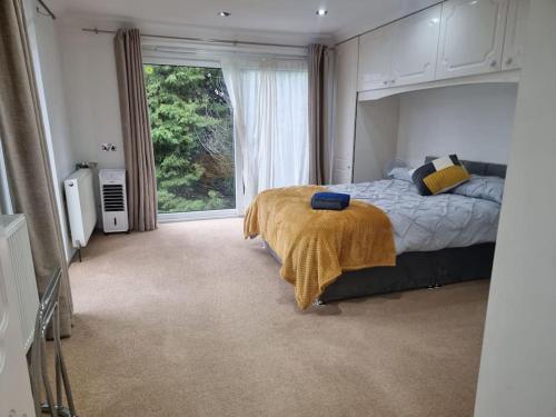 a bedroom with a bed and a large window at Entire Spacious 4 Bedroom Zen House with Garden View in Bromley