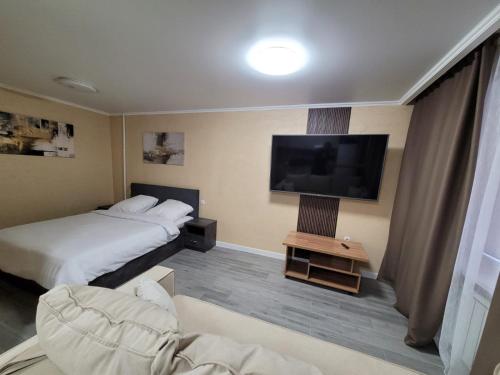 Habitación de hotel con 2 camas y TV de pantalla plana. en Апартаменты посуточно, en Temirtaū