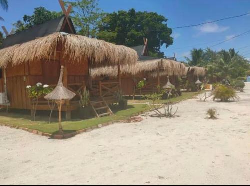 a hut with a straw roof on the beach at Bintan Brzee Beach in Island Bintan - Bungalow 3 in Berakit