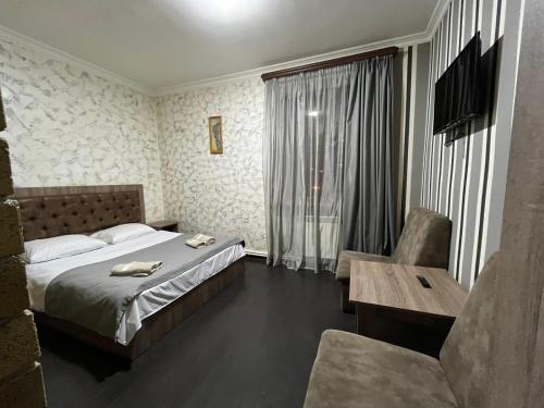1 dormitorio con 1 cama, 1 mesa y 1 silla en Baron Hotel, en Vanadzor