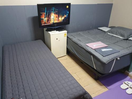 sypialnia z łóżkiem z telewizorem na górze w obiekcie Halla Livingtel w mieście Goyang