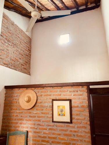 a room with a brick wall and a picture on the wall at CASA SINNING-año1637 in Mompos